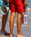 Two people on the beach, one holding Marine Waterproof First Aid Kit For Boat Kayak And Beach With Floating Hard Case And Emergency Medical Supplies.
