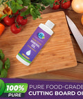 Bottle of 8oz Food Grade Mineral Oil For Cutting Boards And Wood Surfaces on wooden board with vegetables and knife.