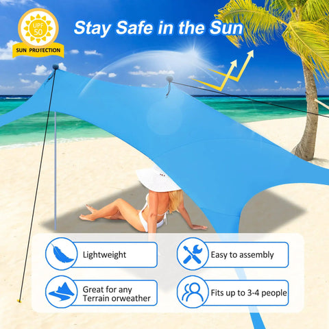 Blue Sun Shield Beach Canopy Tent With UPF 50 Plus Protection on a sunny beach, showing no fuss setup with sandbags and poles