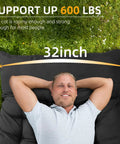 Person lying on Extra Wide 32 Inch Camping Cot With Thick Mattress Holds Up To 600 Lbs, demonstrating size and comfort outdoors.