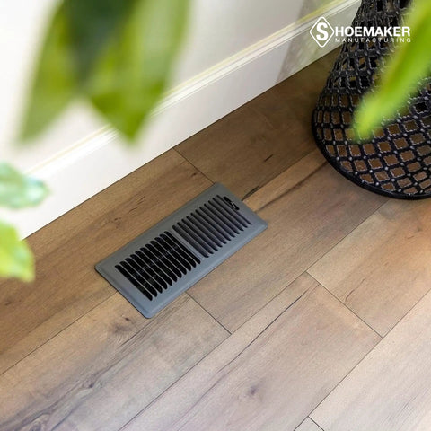 Heavy Duty Boss Grade 4x12 Floor Register Storm Gray Metal Vent Cover installed in wood floor corner view