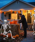 Epic Life Size Halloween Skeleton With Movable Joints, Realistic Gray Plastic Bones by pumpkins on porch at dusk