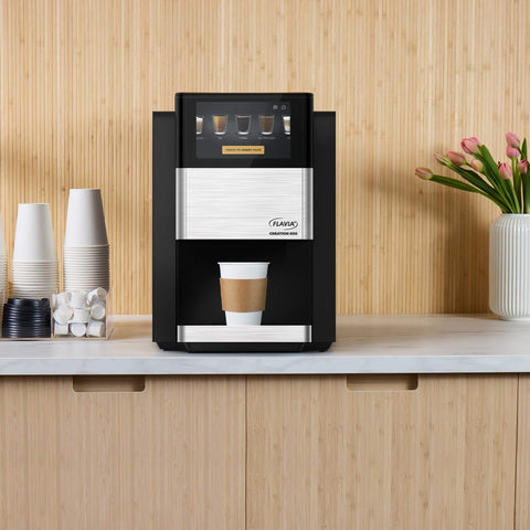 Creation 600 Single Serve Brewer on countertop, black color, brewing coffee cup with in-cup frothing tech, barista quality