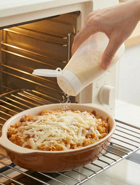 Top Shelf Soft Parmesan Cheese Shaker Set Squeezable Spice Jars With Wide Opening Heavy Duty Plastic Seasoning Dispensers being used to sprinkle cheese over a dish.