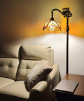 Tiffany Style Arched Floor Lamp With Stained Glass Shade And Jewel Accents, 62 Inch Tall Antique Brown Red Tan Traditional Reading Light next to sofa