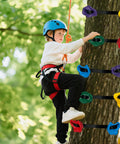 Child climbing tree using 12 Piece Large Ninja Tree Climbing Holds Kit For Kids With 6 Ratchet Straps in bright colors.