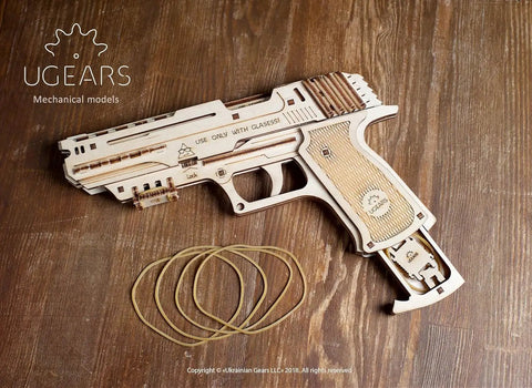 Wolf 01 Handgun 3D Puzzle Rubber Band Gun Mechanical Model Kit For DIY Wood Build, Collectible Hobby Craft, Brain Teaser Puzzle With 60 Rubber Bands, Fires Up To 5 Per Round, 10 Meter Range, Secret Handle Compartment, Torch Mount. Wooden rubber band handgun kit with bands on wood surface.