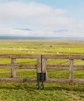 4 Inch Gate Wheels With Spring Loaded Caster And 360 Degree Universal Mount Plate For Wooden Fence And Metal Gates Heavy Duty 220 Lb Capacity Black Absorbs Vibration And Handles Uneven Surfaces Across Concrete Dirt And Grass installed on a wooden gate in a grassy field