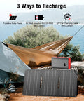 Portable Power Bank With AC Outlet 65W External Battery For Laptop Charging And Outdoor Use On The Go 24000mAh Backup Power Supply For RV Camping Home Emergency Grey Red shown with foldable solar panel by a tent and hammock.