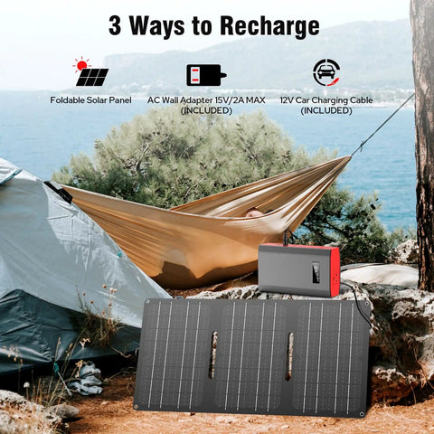 Portable Power Bank With AC Outlet 65W External Battery For Laptop Charging And Outdoor Use On The Go 24000mAh Backup Power Supply For RV Camping Home Emergency Grey Red shown with foldable solar panel by a tent and hammock.
