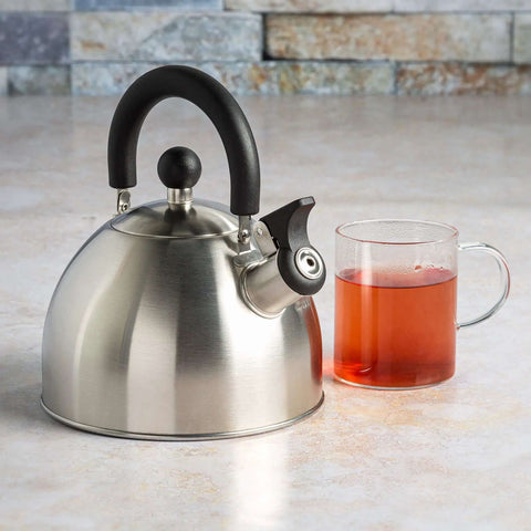 Whistling Stovetop Tea Kettle With Food Grade Stainless Steel, 1.5 Quart Capacity, Brushed Finish With Black Handle next to tea mug