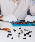 Person using 600 Pcs Tiny Screw Assortment Kit For Glasses Electronics Watches And Laptops M2 M2.5 M3 micro screws on a workbench