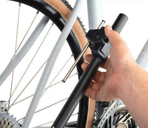 Hand using DAG 3 Derailleur Hanger Alignment Gauge Must Have For Bikes Black With Low Profile Head on bike rear wheel.