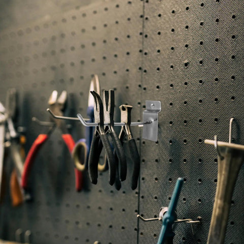 Slatwall Hooks 50 Pack for Pegboard and Wall Displays, Heavy Duty Silver Iron Hangers holding tools on a wall