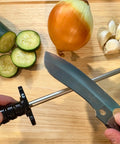 Using 12-Inch Diamond Steel Sharpener DS2E With Extra Fine Grit For Regular Honing And Final Polishing on a knife, surrounded by vegetables.
