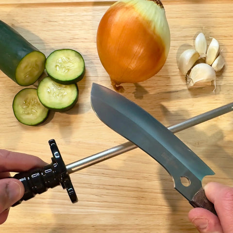 Using 12-Inch Diamond Steel Sharpener DS2E With Extra Fine Grit For Regular Honing And Final Polishing on a knife, surrounded by vegetables.