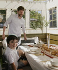 Family enjoying a festive meal inside the 10x12 Ft Deluxe Sukkah Shelter For Sukkot Gatherings With Weatherproof Fabric Walls Bamboo Schach Roof Magnetic Screen Door No Sweat Butter Smooth Quick Setup.