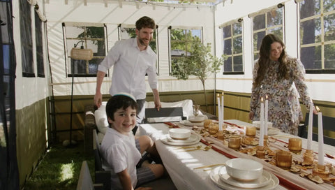 Family enjoying a festive meal inside the 10x12 Ft Deluxe Sukkah Shelter For Sukkot Gatherings With Weatherproof Fabric Walls Bamboo Schach Roof Magnetic Screen Door No Sweat Butter Smooth Quick Setup.