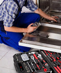 Man using 325 Piece Home Repair Tool Set With Drawer Toolbox Storage Case for dishwasher repair, tools spread out on floor.