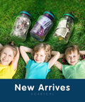 Three kids lying on grass with jars of money labeled new arrives