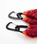 Close-up of red single person camping hammock with durable ripstop fabric and heavy duty straps, includes carabiners, supports up to 300 lbs.