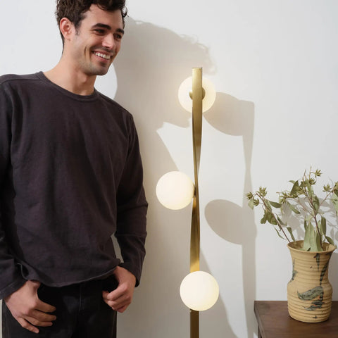 Man standing by Nola Mid Century Modern 3 Globe Floor Lamp For Living Room And Office, Bright LED Twisting Standing Light In Gold Finish