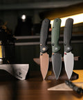 Three Folding Pocket Knives With 3.34 Inch Blade And Button Liner Lock, PVD Coated Steel, displayed standing with ergonomic handles