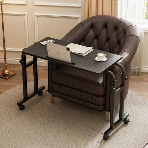Overbed Laptop Desk With Wheels, Adjustable Height And Length Bed Tray Cart For Hospital Or Home Use, Mobile Bedside Table On Casters With A Sturdy Wood And Steel Frame For Easy Glide And Reliable Support next to a leather chair with a laptop and cup displayed