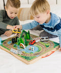 Two kids playing with Portable Wooden Railroad Tabletop Playset With Magnetic Train Cars And Animal Scenery For Toddlers And Preschoolers Age Three Plus Legit Awesome Travel Kit.