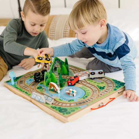 Two kids playing with Portable Wooden Railroad Tabletop Playset With Magnetic Train Cars And Animal Scenery For Toddlers And Preschoolers Age Three Plus Legit Awesome Travel Kit.