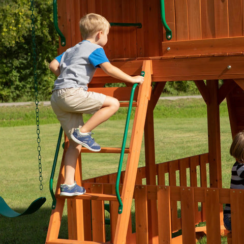 Child climbing ladder on Skyfort II Cedar Wood Swing Set With Wave Slide, Raised Clubhouse, Crow's Nest, outdoor playset.