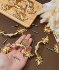 Hand holding one of the Six Piece European Style Vintage Cabinet Handles Pulls 5 Inch Alloy Antique Golden Drawer Knobs, screws nearby.