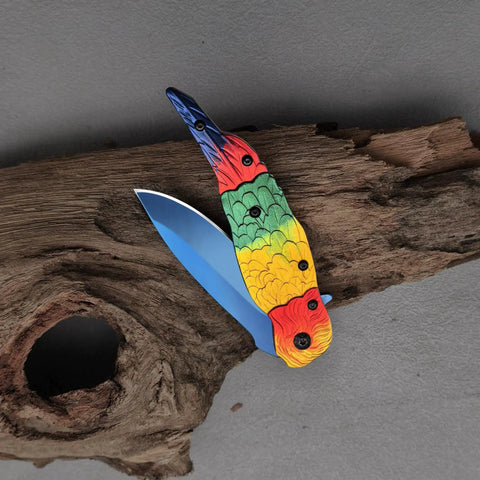 Colorful Parrot Pattern Folding Pocket Knife With Gradient Parrot-Scale Handle, 3-Inch Blue Coated Blade, on wood background