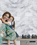 Woman and child in front of Just Peel And Stick Subway Tile Backsplash Kit 3x6 Inches Durable White Granite For Kitchen And Bathroom Easy DIY