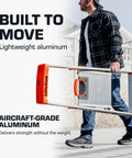 Flip N Lite 5-Foot Aluminum Stepladder With Huge Platform For Stable Footing, No-Slip Feet, Ultra Foldable Ladder With Built-In Tool Tray, Lightweight Yet Tough For Home Projects And Pro Jobs. Man carrying lightweight aluminum stepladder