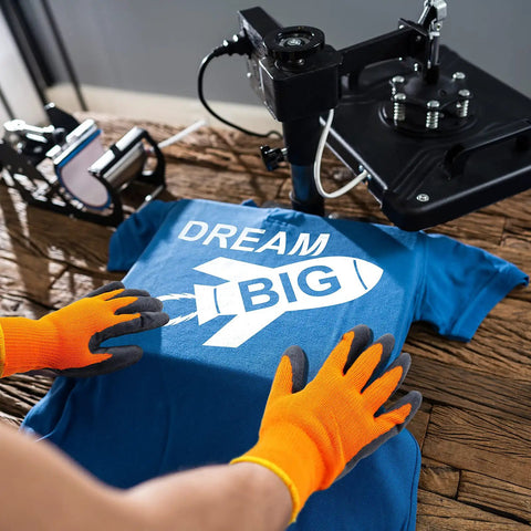 Person using 3 Pairs Heat Resistant Gloves For Heat Press And Sublimation Transfer Printing Orange And Black Durable Polyester Comfort Fit For 3D Vacuum Transfer Machines And Everyday Work handling a t-shirt under a heat press machine