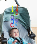 Baby in stroller with 24 colorful teething ring links for babies plastic chain toy set for strollers, car seats, and cribs hanging above.