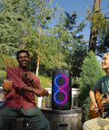 Outdoor party with four people and PartyBox 110 Portable Party Speaker With Built In Lights And Deep Bass 160W Power.