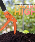 Long Reach Cut And Hold Bypass Pruner 3.5 Ft For Precision Pruning In Gardens with orange handle in garden soil