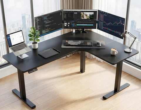 63-Inch L-Shaped Standing Desk With Built-In Power Outlets And Large Power Strip Holder, Electric Height Adjustable Corner Computer Desk, Sit-To-Stand With 3 Preset Heights, Black setup with multiple monitors and laptop in modern office.