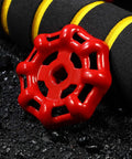 Close-up of a red cast iron valve wheel handle on asphalt, part of a Ten Pack Red Cast Iron Valve Wheel Handles Replacement Shutoff Hand Wheels With Flat Bottom Design For Hose And Faucet Applications Durable Gate Valve Replacement Parts.