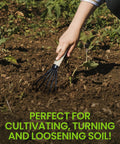 A hand using Ninja Claw Garden Hand Rake Cultivator with 5 Tine Steel Prongs and Wood Handle Rust Resistant Military Grade Tiller.
