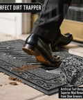 Person wiping shoes on Tough As Nails Heavy Duty Welcome Mat For Home Entrance Indoor Outdoor Front Porch Door Mat 29.5x17 Waterproof Low Profile Dirt Trapper For Mud Dust Sand Patio Garage Office, showing dirt removal.