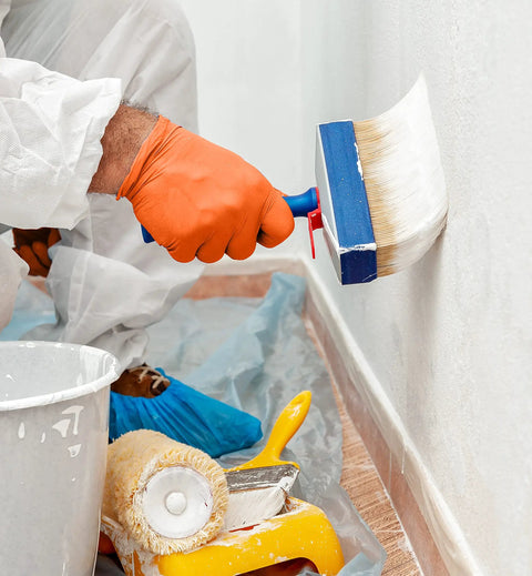 Orange Lightning Gloves OR-L Large gloves worn while painting, showcasing industrial use and protection in a work environment.