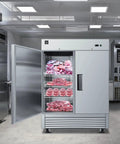 Heavy Duty Commercial Reach In Freezer, Two Door Stainless Steel Bottom Mount Upright Unit loaded with frozen meats in restaurant kitchen.