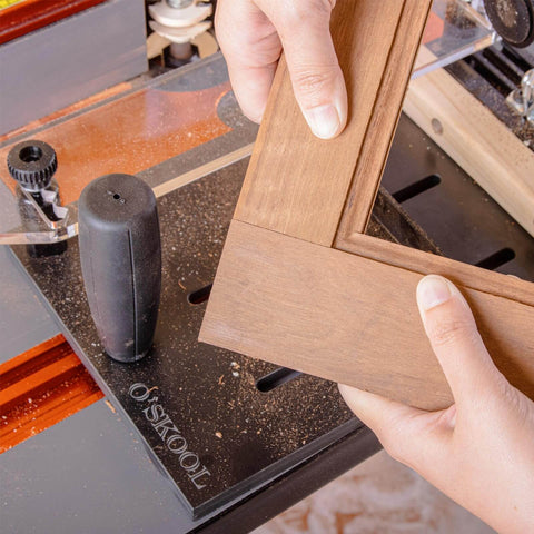 Close-up of Pro Grade Rail Coping Sled Router Table Jig for cabinet doors on a woodworking table with phenolic base.