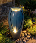 32 Inch Outdoor Jar Water Fountain With LED Lights, Vintage Blue Cracked Jar Design, cascading waterfall in garden setting.