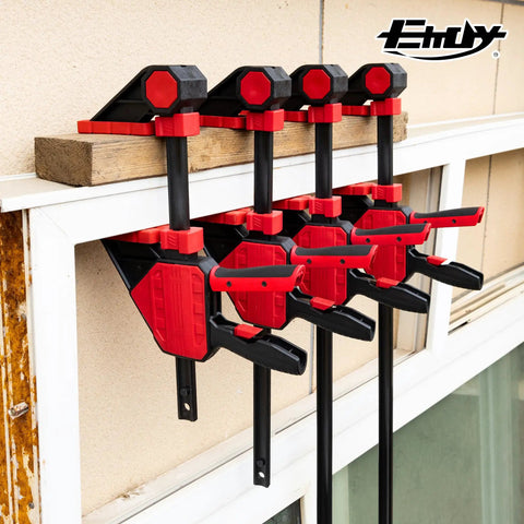 Heavy Duty Twenty Four Inch Bar Clamps Set With Five Hundred Fifty Pound Rock Solid Grip For Woodworking And Carpentry mounted on a wall.