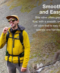 Osprey Hydraulics bite valve replacement; front view of a hiker in a yellow jacket outdoors.