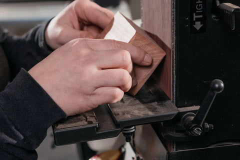Close-up of hands using Six Inch Fortyeight Belt And Twelve Inch Disc Sander Combo Pairing One Point Five Horsepower Dual Voltage Motor.